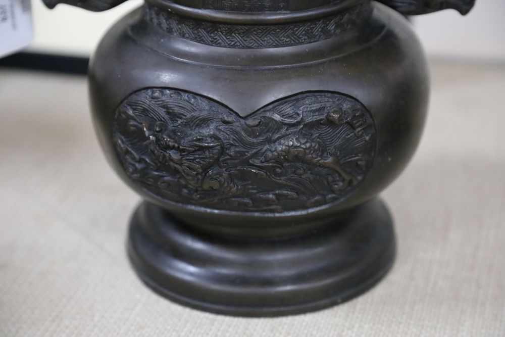 A large 19th century Japanese bronze two handled vase, cast with mythical beasts, 34cm high